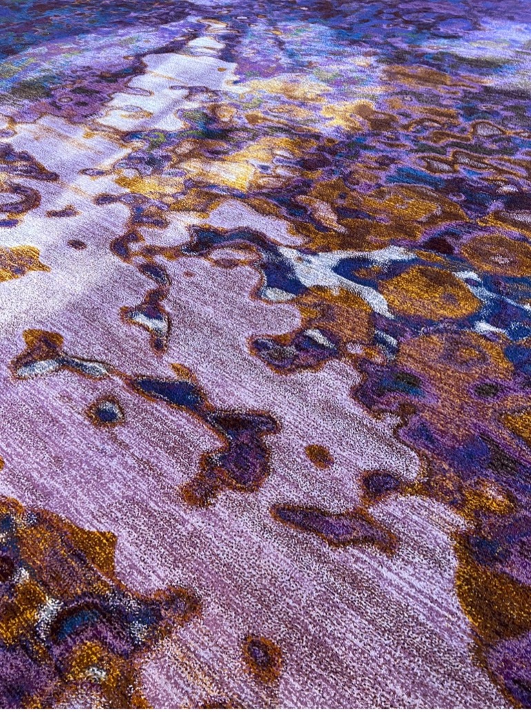 The carpet in the ballroom is a floral-like pattern of deep and light purple, and brown.