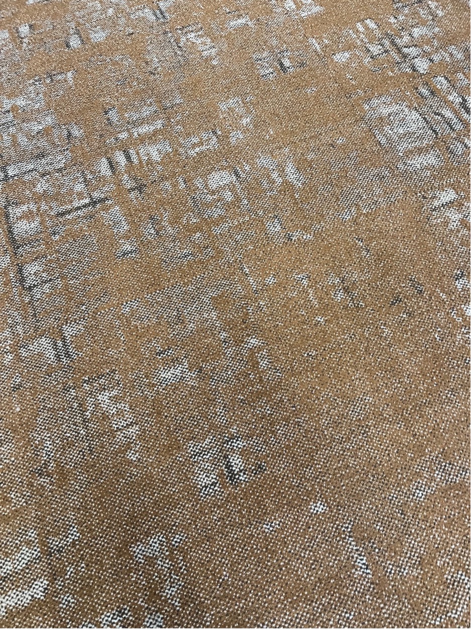 Brown and white patterned carpet with a faint black grid.